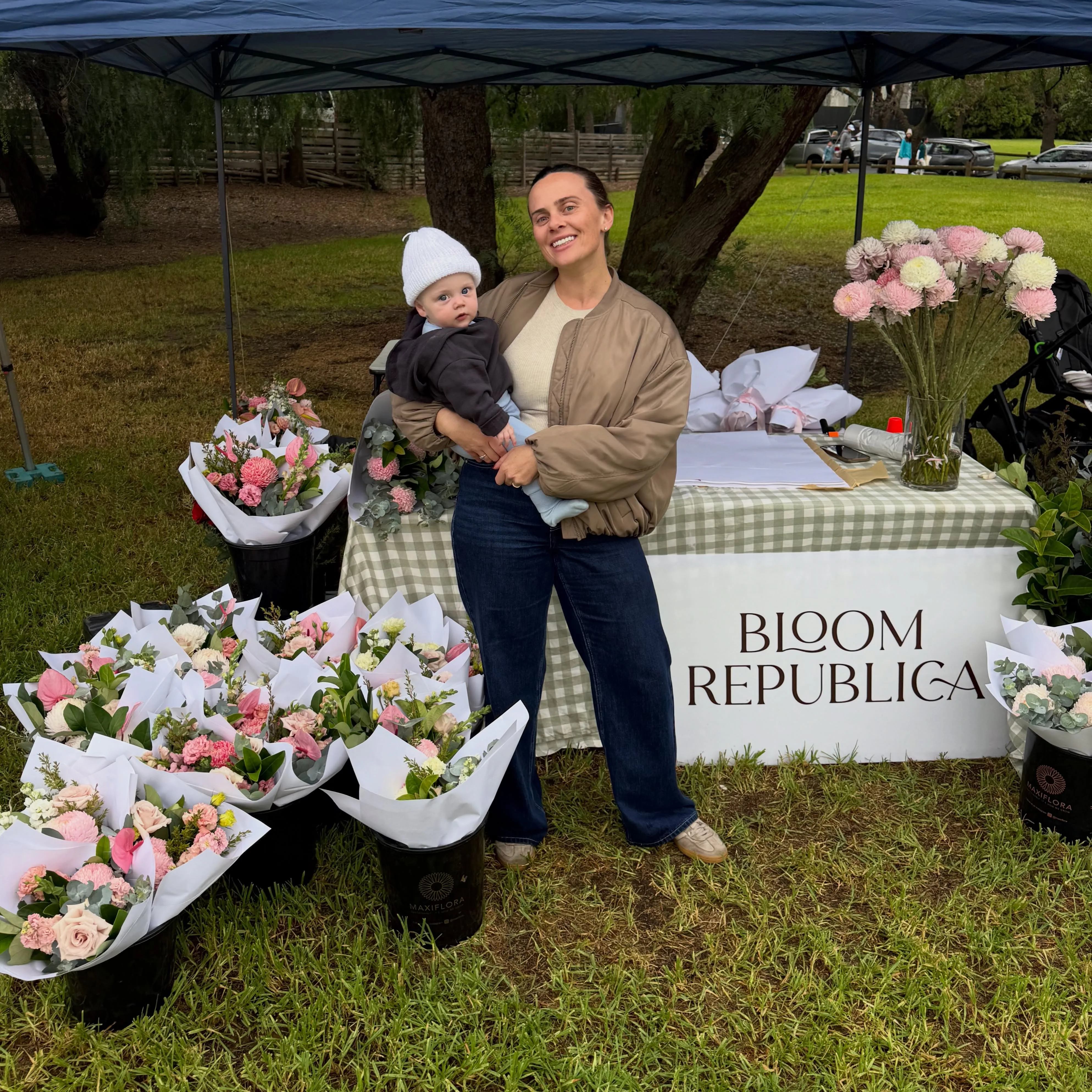 Allie at the Bloom Republica market stall surrounded by wrapped pastel bouquets