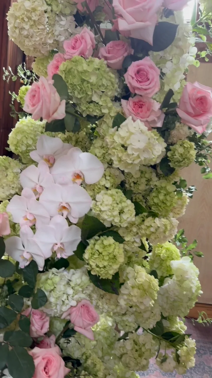 Blush and red rose centrepiece on a styled outdoor dining table with gold cutlery