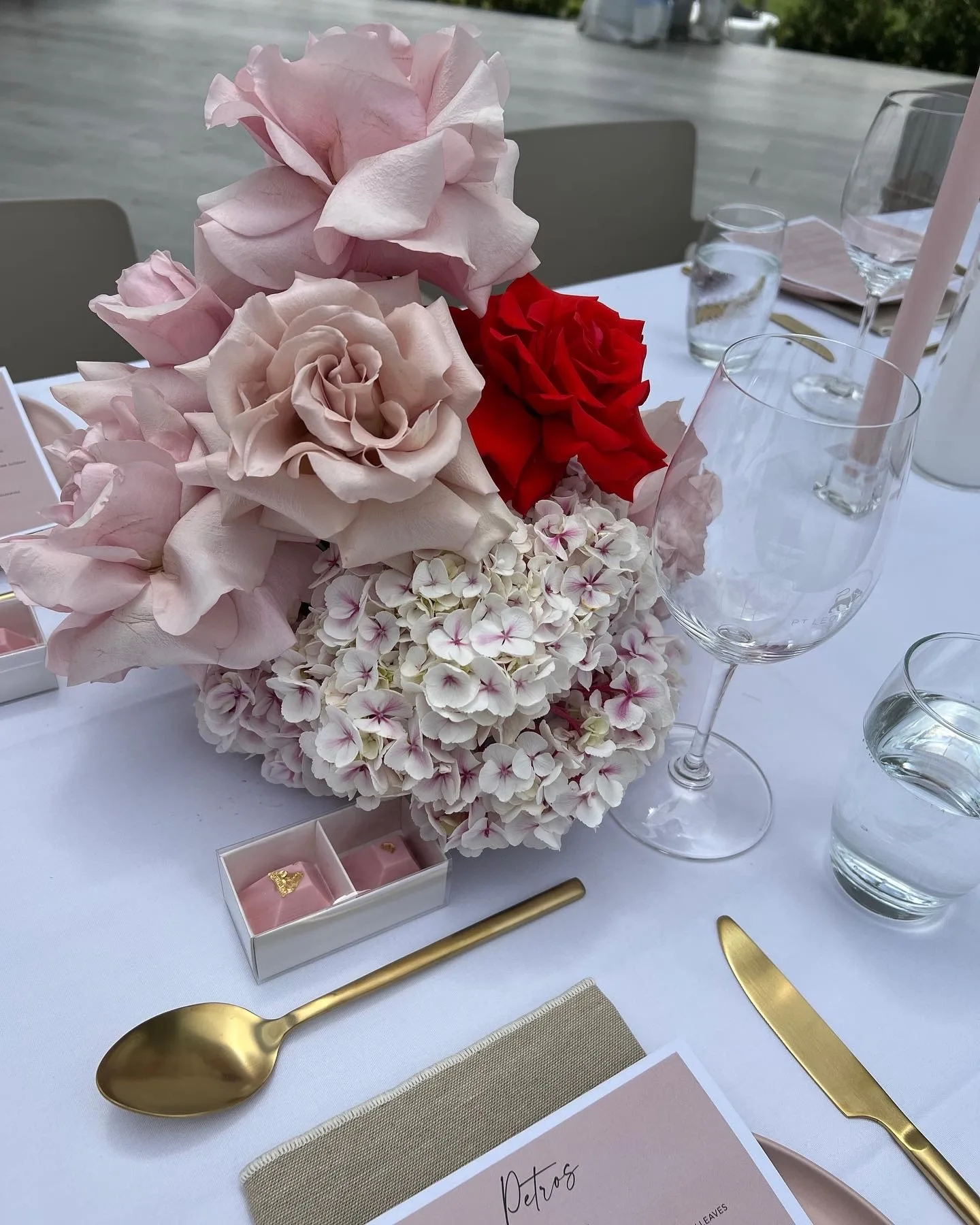 Lush pink-and-white floral installation against timber doors on a patterned rug